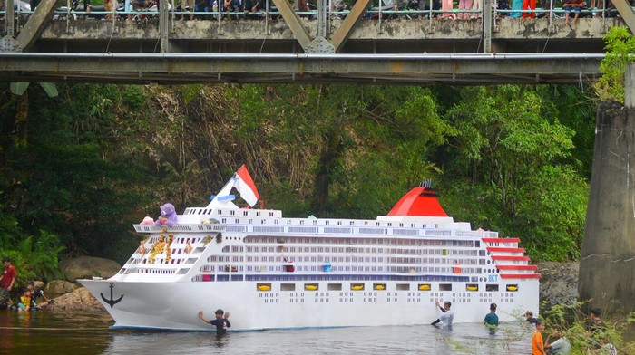 Sejumlah warga mendorong kajang (perahu yang dihias serupa kapal pesiar) saat digelarnya tradisi Bakajang di Sungai Batang Mahek, Nagari Gunuang Malintang, Kabupaten Limapuluhkota, Sumatera Barat, Kamis (5/5/2022). Bakajang merupakan tradisi turun temurun dengan menghias perahu yang dilakukan lima jorong di nagari itu selepas Idul Fitri, dalam rangka meningkatkan silaturahmi antara anak nagari, ninik mamak, alim ulama dan pemerintah, dengan tujuan mempererat persatuan, melestarikan adat budaya. ANTARA FOTO/Iggoy el Fitra/nz