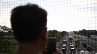 Muhammad Suharto (49), mengaku sengaja datang ke jembatan layang karena diminta rekan kerjanya. Dia mengaku menjadi informan kondisi lalu lintas di Tol Cikampek saat arus balik.