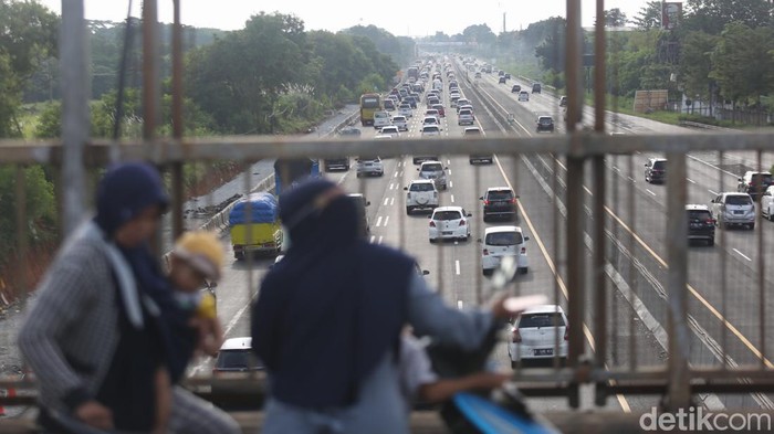Sejumlah warga menonton kemacetan yang terjadi di ruas Tol Cikampek arah Jakarta saat pemberlakuan one way. Aksi itu dilakukan untuk membagikan informasi ke temannya yang mudik lewat grup WhatsApp (WA), Jumat, (6/5/2022).