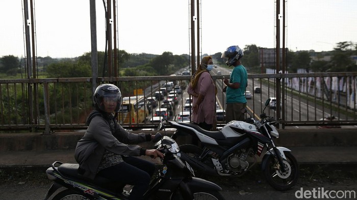 Sejumlah warga menonton kemacetan yang terjadi di ruas Tol Cikampek arah Jakarta saat pemberlakuan one way. Aksi itu dilakukan untuk membagikan informasi ke temannya yang mudik lewat grup WhatsApp (WA), Jumat, (6/5/2022).