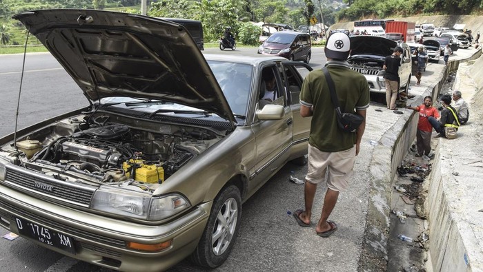 Nggak Kuat Nanjak, Puluhan Mobil Mogok di Tanjakan Gentong Hingga Bikin Macet Sejumlah kendaraan pemudik yang mengalami kerusakan parkir di bahu Jalan Lingkar Gentong Bawah, Kadipaten, Kabupaten Tasikmalaya, Jawa Barat, Jumat (6/5/2022). Puluhan kendaraan pemudik mengalami mogok atau kerusakan akibat tidak kuat menanjak sehingga arus lalu lintas di Jalur Selatan tersendat. ANTARA FOTO/Adeng Bustomi/nym.