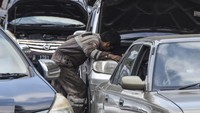 Montir memperbaiki mobil pemudik yang rusak dan parkir di bahu Jalan Lingkar Gentong. Puluhan kendaraan pemudik mengalami mogok atau kerusakan akibat tidak kuat menanjak sehingga arus lalu lintas di Jalur Selatan tersendat.