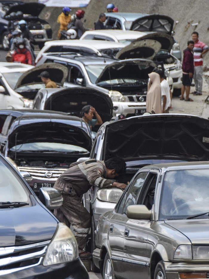 Nggak Kuat Nanjak, Puluhan Mobil Mogok di Tanjakan Gentong Hingga Bikin Macet Sejumlah kendaraan pemudik yang mengalami kerusakan parkir di bahu Jalan Lingkar Gentong Bawah, Kadipaten, Kabupaten Tasikmalaya, Jawa Barat, Jumat (6/5/2022). Puluhan kendaraan pemudik mengalami mogok atau kerusakan akibat tidak kuat menanjak sehingga arus lalu lintas di Jalur Selatan tersendat. ANTARA FOTO/Adeng Bustomi/nym.