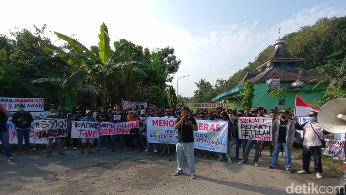 Aksi damai di TPST Piyungan, Bantul. Tampak warga membentangkan spanduk dan menutup akses jalan ke TPST dengan tumpukan batu, Sabtu (7/5/2022).