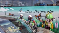 Polwan bersama badut karakter menghibur wisatawan yang terjebak kemacetan di jalur wisata Puncak.