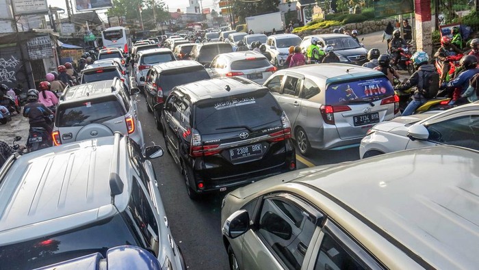 ANTREAN KENDARAAN DI PUNCAK BOGOR H+4 Polwan bersama badut karakter menghibur wisatawan yang terjebak kemacetan di jalur wisata Puncak, Gadog, Kabupaten Bogor, Jawa Barat, Sabtu (7/5/2022). Polres Bogor mencatat 272 ribu kendaraan memasuki kawasan wisata Puncak sejak Lebaran hingga H+4 sehingga pemberlakuan sistem buka tutup jalan dan sistem satu arah tetap diberlakukan untuk mengurai antrean kendaraan. ANTARA FOTO/Yulius Satria Wijaya/nym.