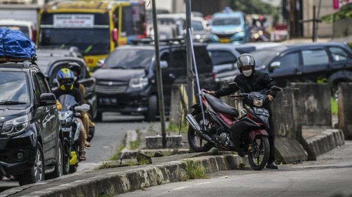 KEMACETAN IMBAS PENERAPAN ONE WAY DI TOL JAPEK Pengendara sepeda motor melewati trotoar untuk menghindari kemacetan di Jalan Raya Kalimalang, Bekasi, Jawa Barat, Sabtu (7/5/2022). Ruas jalan arteri Kalimalang arah Bekasi terpantau mengalami kepadatan kendaraan hingga sekitar empat kilometer imbas dari diberlakukannya sistem satu jalur (one way) di Tol Jakarta-Cikampek. ANTARA FOTO/Galih Pradipta/nym.