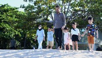 Setelah melepas sepatu, Presiden Jokowi mengajak cucunya berjalan ke bibir pantai.