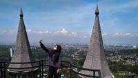 Pengunjung berswafoto di antara kedua atap runcing.