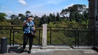 Pengunjung berpose swafoto berlatar belakang alam.