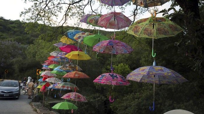 Umbrellas are displayed for sale by a Pakistani vendor on a roadside in Murree, Pakistan, near Islamabad, Pakistan, Friday, May 6, 2022. (AP Photo/Rahmat Gul)