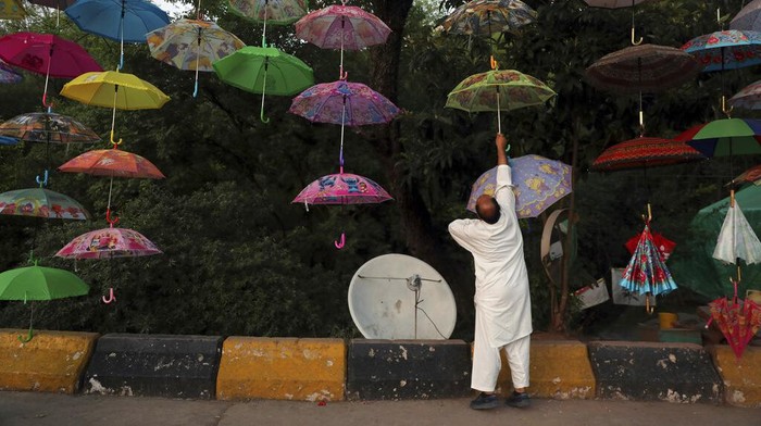 Umbrellas are displayed for sale by a Pakistani vendor on a roadside in Murree, Pakistan, near Islamabad, Pakistan, Friday, May 6, 2022. (AP Photo/Rahmat Gul)