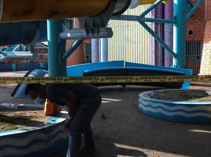 Polisi melakukan olah tempat kejadian perkara (TKP) di lokasi ambrolnya seluncuran wahana permainan air di Kenjeran Water Park, Surabaya, Jawa Timur, Sabtu (7/5/2022). Sekitar 15 pengunjung mengalami luka-luka akibat terjatuh dari seluncuran yang ambrol di ketinggian sekitar 10 meter tersebut. ANTARA FOTO/Didik Suhartono/tom.