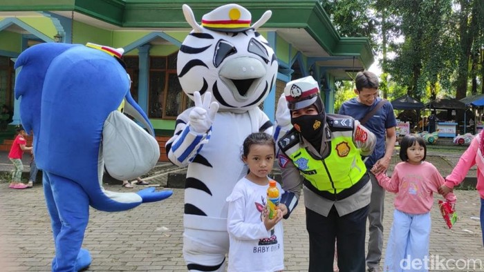 Aksi polwan dan badut hibur warga.