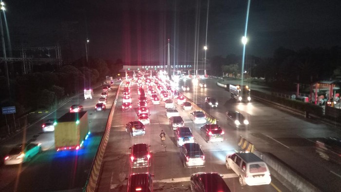 Antrean kendaraan mengular di Gerbang Tol (GT) Cikupa, Kabupaten Tangerang, arah Jakarta, Minggu (8/5/2022) malam. Sebanyak 14 gardu dioperasionalkan untuk mengurai kepadatan di Gerbang Tol Cikupa arah Jakarta.