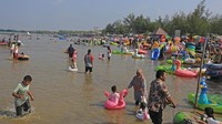 Warga memanfaatkan sisa libur cuti bersama atau hari terakhir libur Lebaran untuk berwisata bersama keluarga di pantai tersebut. ANTARA FOTO/Dedhez Anggara.
