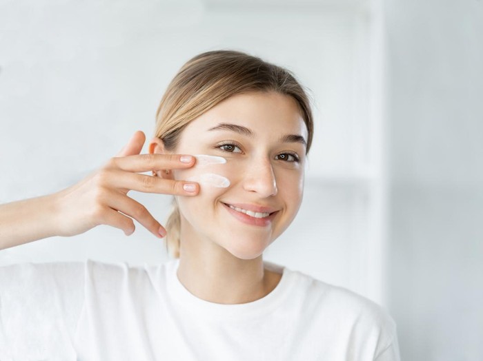 Natural beauty. Healthy skin. Dermatology hygiene. Cheerful smiling woman touching healthy fresh face on light defocused bathroom at morning.