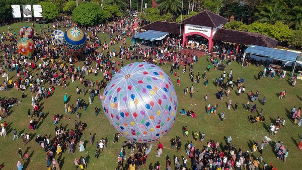 Foto udara sejumlah warga menerbangkan balon udara yang ditambatkan di tanah saat Balloon Attraction Pekalongan 2022 di Lapangan Mataram, Kota Pekalongan, Jawa Tengah, Minggu (8/5/2022).