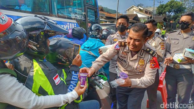 Polisi membagikan minuman gratis.
