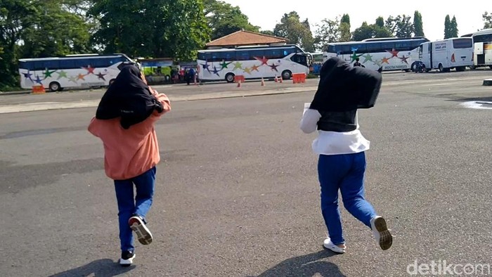 Sejumlah penumpang berlarian kecil mengejar bus di Terminal Pekalongan, Minggu (8/5/2022).
