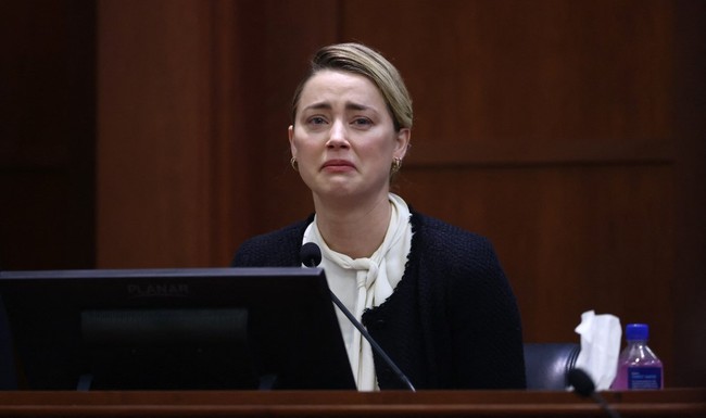 Sambil menangis, Amber Heard membongkar sederet pengakuan tentang KDRT yang disebut dilakukan mantan suaminya, Johnny Depp, dalam persidangan pada Kamis (5/5/2022). Foto: AFP/JIM LO SCALZO