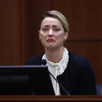 Sambil menangis, Amber Heard membongkar sederet pengakuan tentang KDRT yang disebut dilakukan mantan suaminya, Johnny Depp, dalam persidangan pada Kamis (5/5/2022). Foto: AFP/JIM LO SCALZO