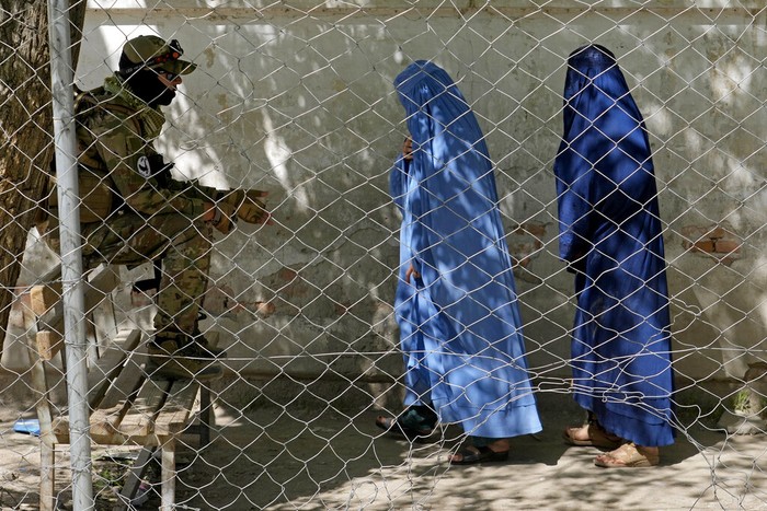 A woman wearing a burka walks through a bird market as she holds her child, in downtown Kabul, Afghanistan, Sunday, May 8, 2022. Afghanistan’s Taliban rulers on Saturday ordered all Afghan women to wear head-to-toe clothing in public — a sharp, hard-line pivot that confirmed the worst fears of rights activists and was bound to further complicate Taliban dealings with an already distrustful international community. (AP Photo/Ebrahim Noroozi)