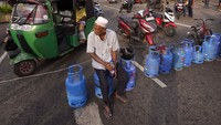 Tampak seorang warga duduk di atas tabung LPG saat ikut serta dalam aksi protes imbas krisis pasokan kebutuhan pokok yang terjadi karena dipicu oleh krisis ekonomi terburuk yang tengah dialami Sri Lanka.  