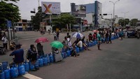 Sejumlah warga duduk di atas tabung gas di tengah aksi protes memblokir jalan di Ibu Kota Kolombo, Sri Lanka, Minggu (8/5/2022).