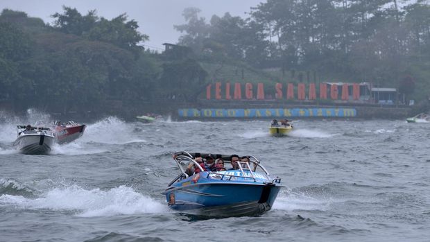 Foto udara sejumlah wisatawan menikmartim suasana kawasan wisata Telaga Sarangan di Magetan, Jawa Timur, Minggu (8/5/2022). Ribuan wisatawan dari berbagai daerah memanfaatkan hari terakhir libur Lebaran untuk berwisata di destinasi wisata alam unggulan di wilayah Kabupaten Magetan tersebut. ANTARA FOTO/Fikri Yusuf/YU