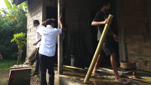 Pemilik rumah dan warga membersihkan puing-puing yang terbakar