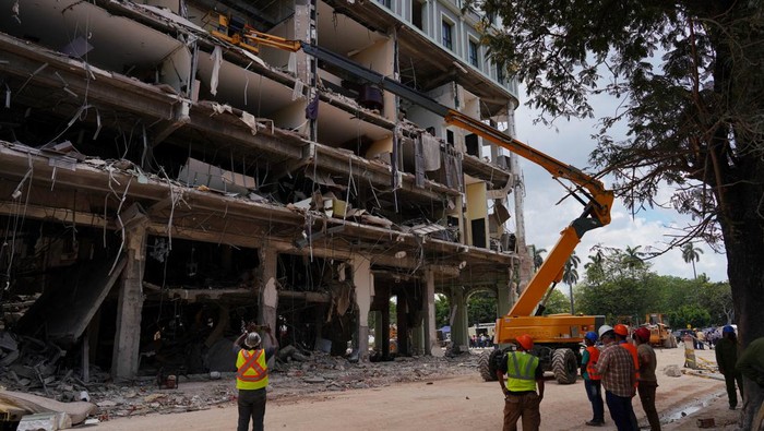 Emergency personnel are lifted by a crane at the Saratoga Hotel two days after it suffered an explosion, in Havana, Cuba May 8, 2022. REUTERS/Alexandre Meneghini