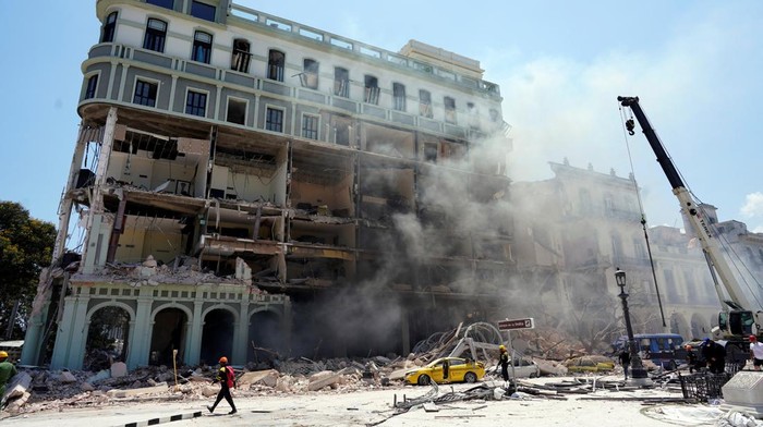 Ledakan Mengguncang Hotel Paling Eksklusif di Kuba Emergency personnel are lifted by a crane at the Saratoga Hotel two days after it suffered an explosion, in Havana, Cuba May 8, 2022. REUTERS/Alexandre Meneghini