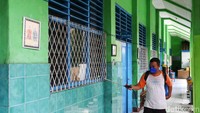 Di masa libur ini, petugas tampak sibuk membersihkan dan menyemprotkan disinfektan di dalam dan luar kelas.