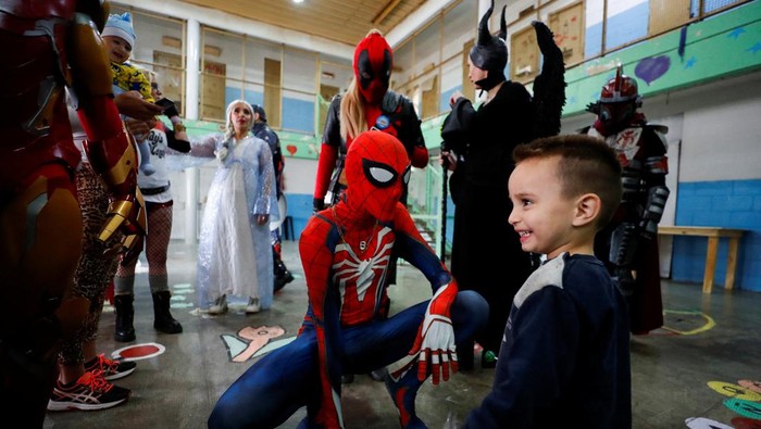 Argentine volunteer and member of the so-called Hero Club (Club de Heroes), Hernando Adolfo Pose, who impersonates Ironman, plays with the son of an inmate during a visit at the 33rd prison in Los Hornos as part of a wider program for vulnerable minors, on the outskirts of Buenos Aires, Argentina April 30, 2022. Picture taken April 30, 2022. REUTERS/Agustin Marcarian