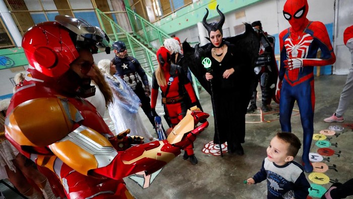 Argentine volunteer and member of the so-called Hero Club (Club de Heroes), Hernando Adolfo Pose, who impersonates Ironman, plays with the son of an inmate during a visit at the 33rd prison in Los Hornos as part of a wider program for vulnerable minors, on the outskirts of Buenos Aires, Argentina April 30, 2022. Picture taken April 30, 2022. REUTERS/Agustin Marcarian