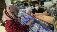 Dalam transaksi jual beli emas tersebut tampak para pekerja toko perhiasan emas disibukkan melayani calon pembeli yang mayoritas kaum perempuan.  