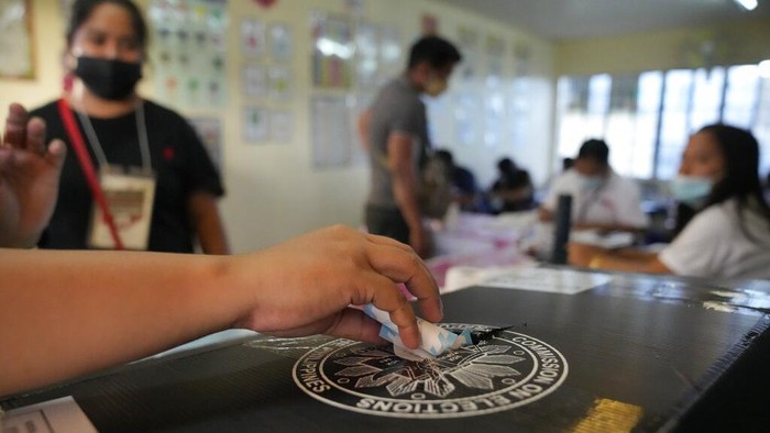Voters enter a polling center Monday, May 9, 2022 in Quezon City, Philippines. Filipinos were voting for a new president Monday, with the son of an ousted dictator and a champion of reforms and human rights as top contenders in a tenuous moment in a deeply divided Asian democracy. (AP Photo/Aaron Favila)