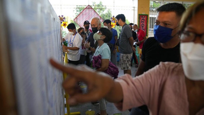 Voters enter a polling center Monday, May 9, 2022 in Quezon City, Philippines. Filipinos were voting for a new president Monday, with the son of an ousted dictator and a champion of reforms and human rights as top contenders in a tenuous moment in a deeply divided Asian democracy. (AP Photo/Aaron Favila)