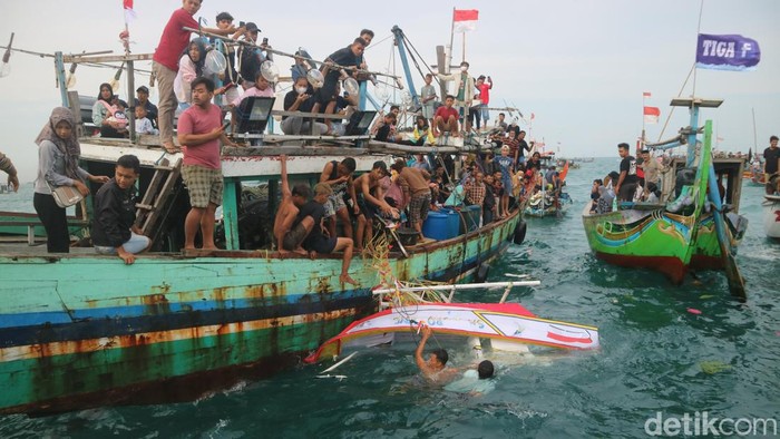 Kapal nelayan berebut sesaji kepala kerbau dalam tradisi Pesta Lomban di Jepara, Senin (9/5/2022).