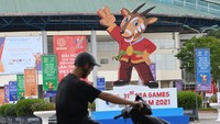 Pengendara sepeda motor melintasi gambar maskot SEA Games 2021 Vietnam, Hanoi Saola, di Kota Bac Ninh.