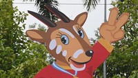 Petugas keamanan berjalan melintasi gambar maskot SEA Games 2021 Vietnam, Hanoi Saola, di Kota Bac Ninh.