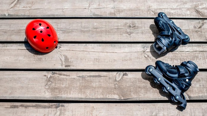 sepatu roda Skating rollers and red helmet on the wooden boards. Top view with space for your text