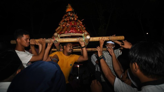 Warga membawa mandura hias (makanan khas terbuat dari beras ketan) menuju masjid saat perayaan Lebaran Mandura di Kampung Baru di Palu, Sulawesi Tengah, Minggu (8/5/2022). Lebaran Mandura merupakan tradisi masyarakat setempat yang dilaksanakan setelah menjalani puasa Syawal. ANTARA FOTO/Mohamad Hamzah/YU