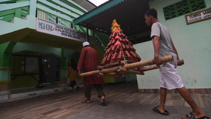 Warga membawa mandura hias (makanan khas terbuat dari beras ketan) menuju masjid saat perayaan Lebaran Mandura di Kampung Baru di Palu, Sulawesi Tengah, Minggu (8/5/2022). Lebaran Mandura merupakan tradisi masyarakat setempat yang dilaksanakan setelah menjalani puasa Syawal. ANTARA FOTO/Mohamad Hamzah/YU