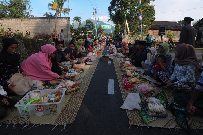 Warga mengikuti kendurian Tradisi Lebaran Sapi di lereng Gunung Merapi, Mlambong, Sruni, Musuk, Boyolali, Jawa Tengah, Senin (9/5/2022). Tradisi lebaran sapi yang telah dilakukan turun temurun pada bulan Syawal lebaran ketupat tersebut merupakan simbol rasa syukur masyarakat setempat atas rezeki hasil hewan ternak sapi sebagai sumber penghasilan. ANTARA FOTO/Aloysius Jarot Nugroho/rwa.