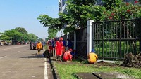Puluhan petugas membersihkan rumput-rumput liar dan memungut sampah yang berserakan di luar stadion.