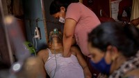 Manisha Bashu menekan dada ayahnya yang kesulitan bernapas setelah merasa tidak sadarkan diri saat menerima bantuan oksigen di Gurudwara (kuil Sikh) di tengah penyebaran penyakit virus corona di Ghaziabad, India, 30 April 2021. REUTERS/Adnan Abidi