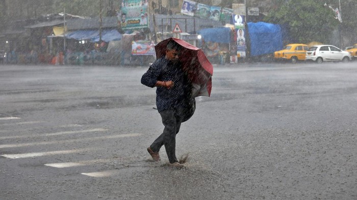INDIA-STORM/ A man with an umbrella crosses a road during heavy rains caused by Cyclone Asani, in Kolkata, India, May 10, 2022. REUTERS/Rupak De Chowdhuri