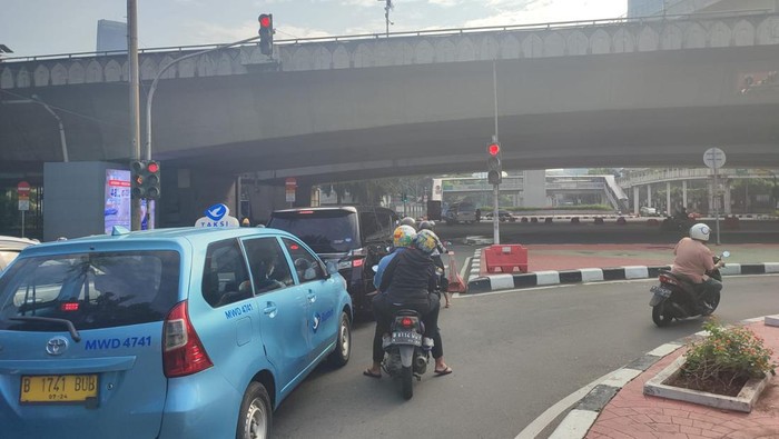 Kondisi lalu lintas di lampu merah Kuningan Jaksel saat penerapan Ganjil Genap usai libur lebaran.
